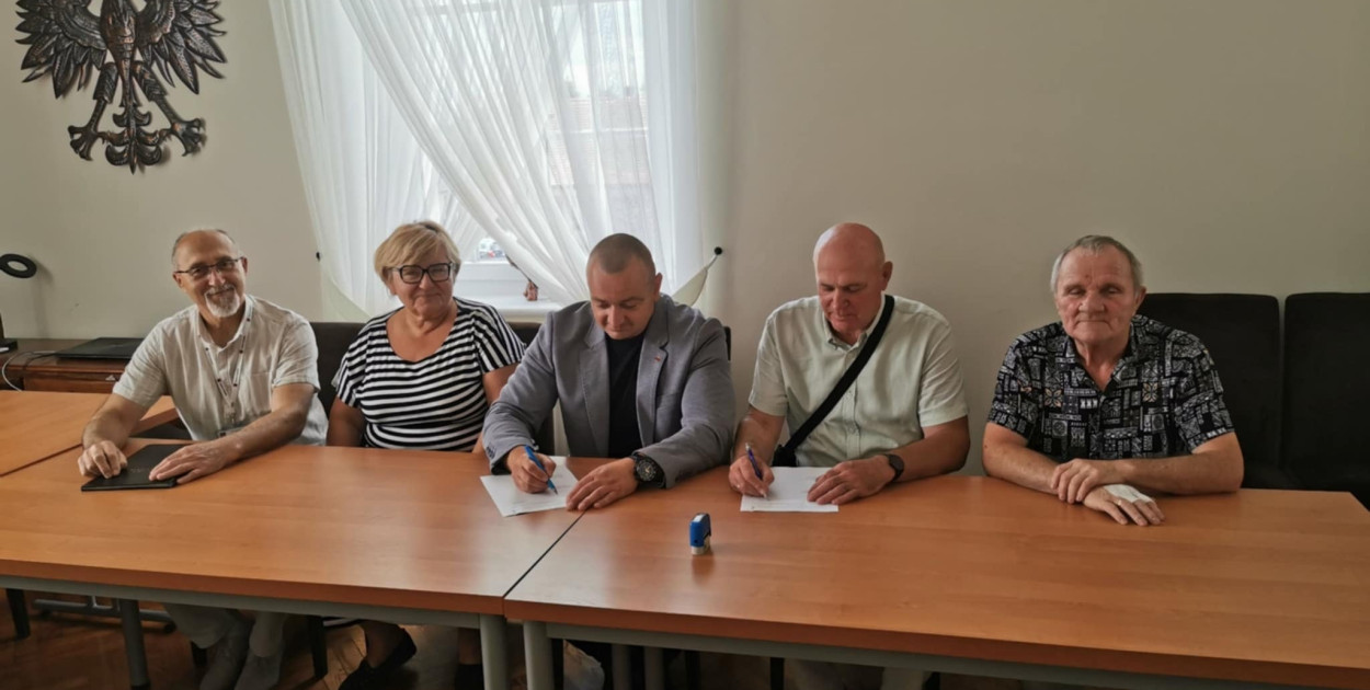 Podpisanie umowy. Wiesław Popiołek (urząd miasta), Barbara Gościniak (zarząd spółdzielni), burmistrz Tomasz Lesiński, prezes Roman Bartoszek i Roman Nowaczyk (członek zarządu)