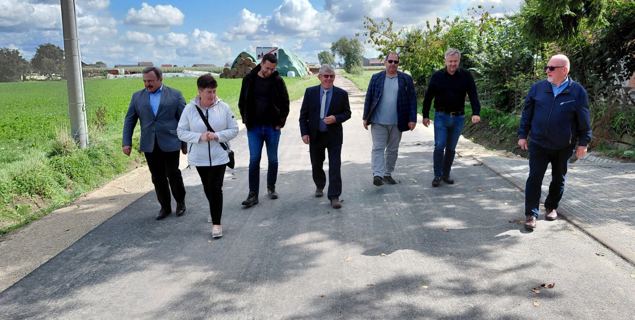 Urzędnicy, radni i mieszkańcy przechadzają się nową drogą w Wykach